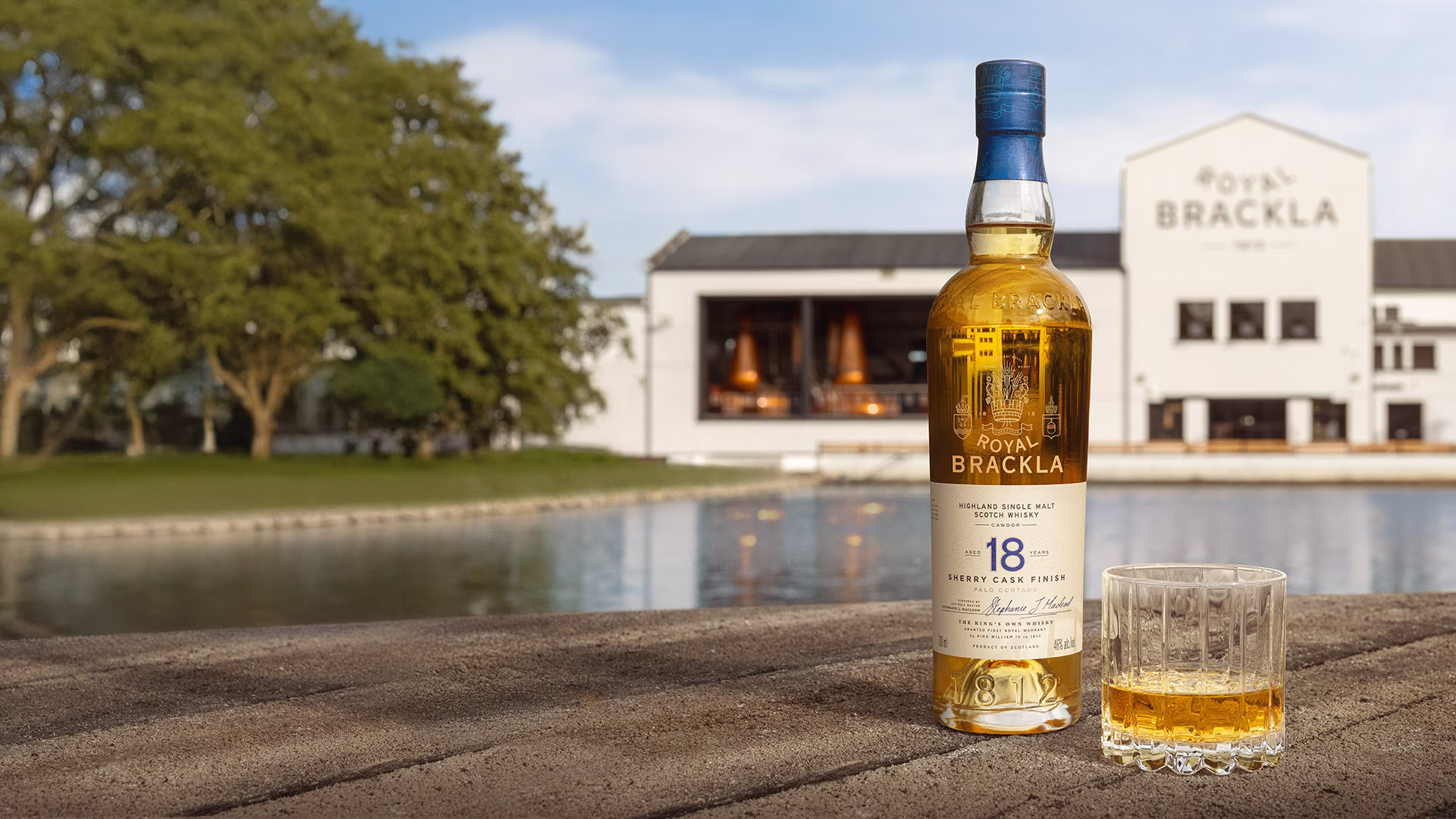 Bottle of Royal Brackla 18-year-old Highland Single Malt Scotch Whisky with glass of amber-gold whisky.