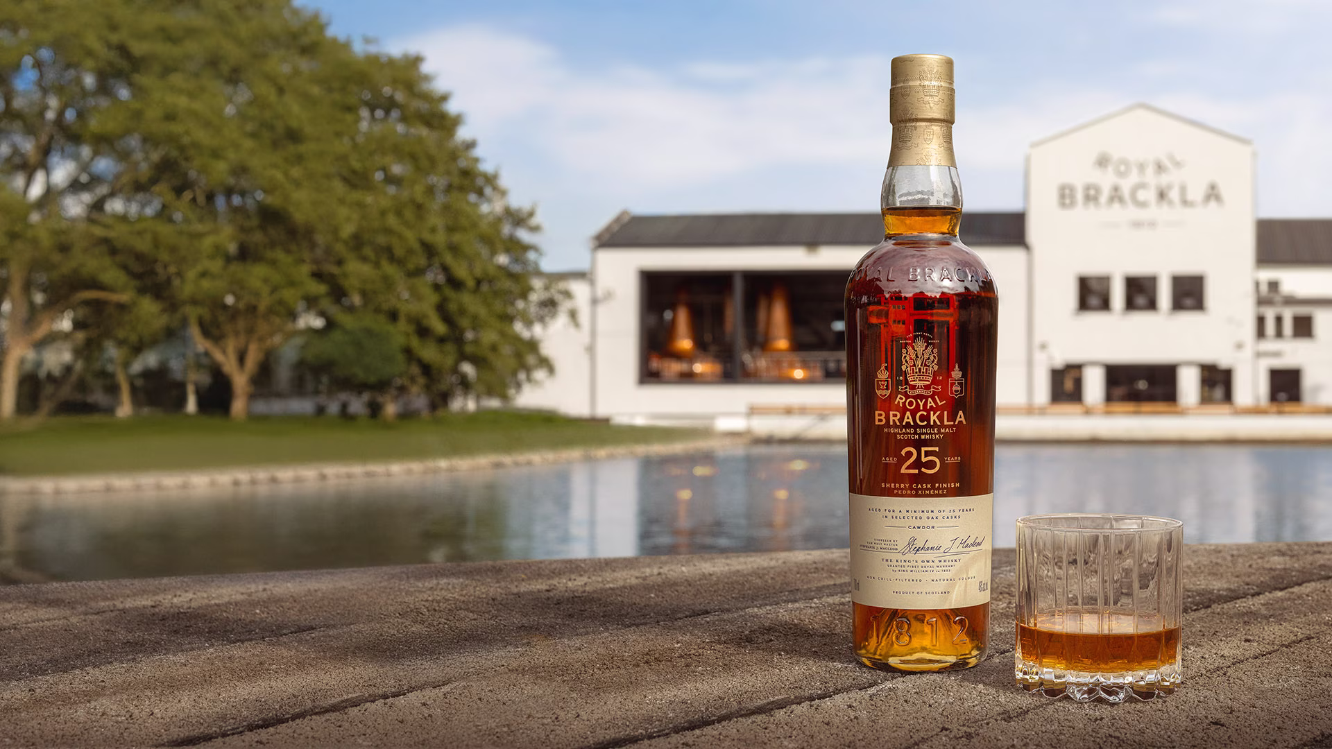 Bottle of Royal Brackla 25-year-old Highland Single Malt Scotch Whisky with glass of amber whisky.